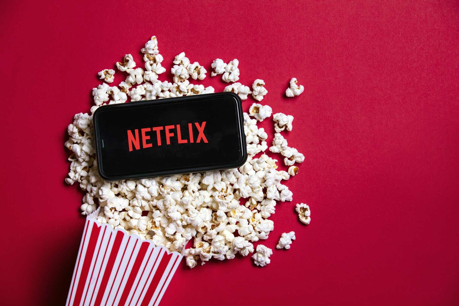 Netflix logo on a smartphone with popcorn