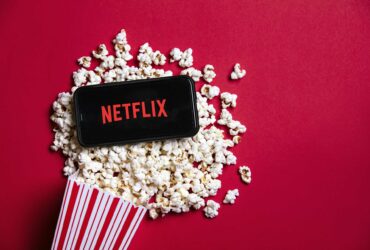 Netflix logo on a smartphone with popcorn