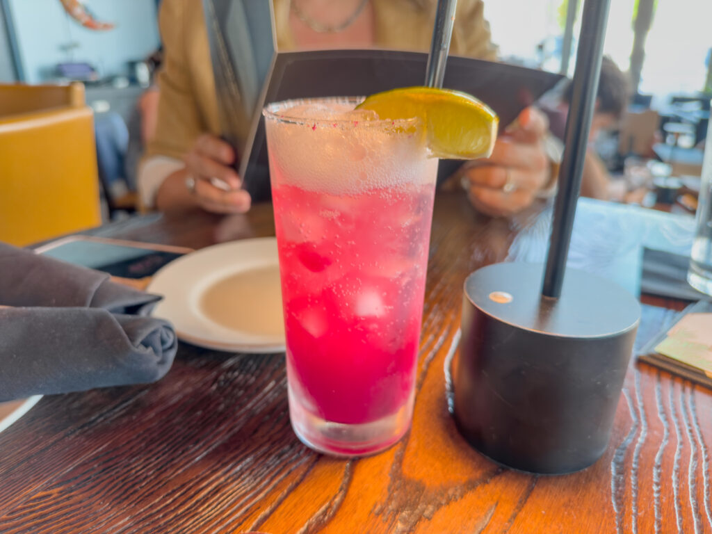 Kolucan Mexican Bar & Grill - Como La Flor mocktail at Kolucan Sarasota, a bright pink hibiscus and grapefruit drink with a lime wedge