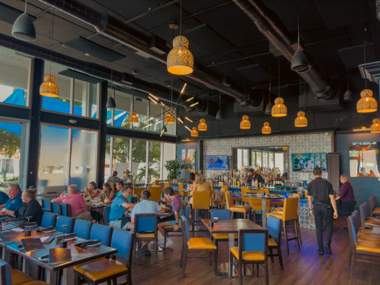 Kolucan Mexican Bar & Grill - Dining room and bar at Kolucan Mexican Bar & Grill in Sarasota with mustard-yellow chairs and patterned tilework