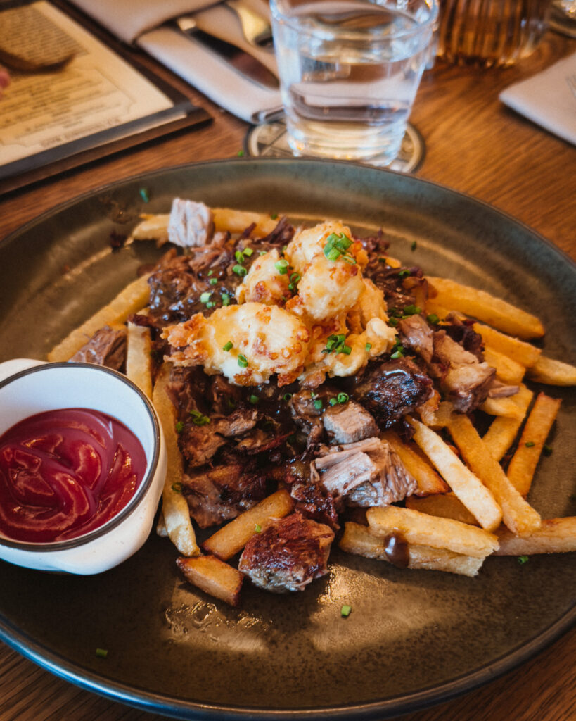 Allswell - Waterside Place Review 77 Steak tip poutine at Allswell with hand cut fries, breaded cheese curds, and pan gravy, served with ketchup