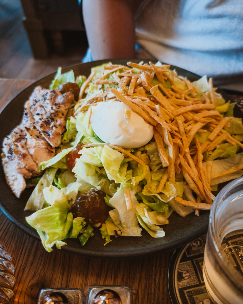 Allswell - Waterside Place Review 83 Mezcali salad with grilled chicken at Allswell, topped with tortilla crunch, charred onion crema, and heirloom tomatoes