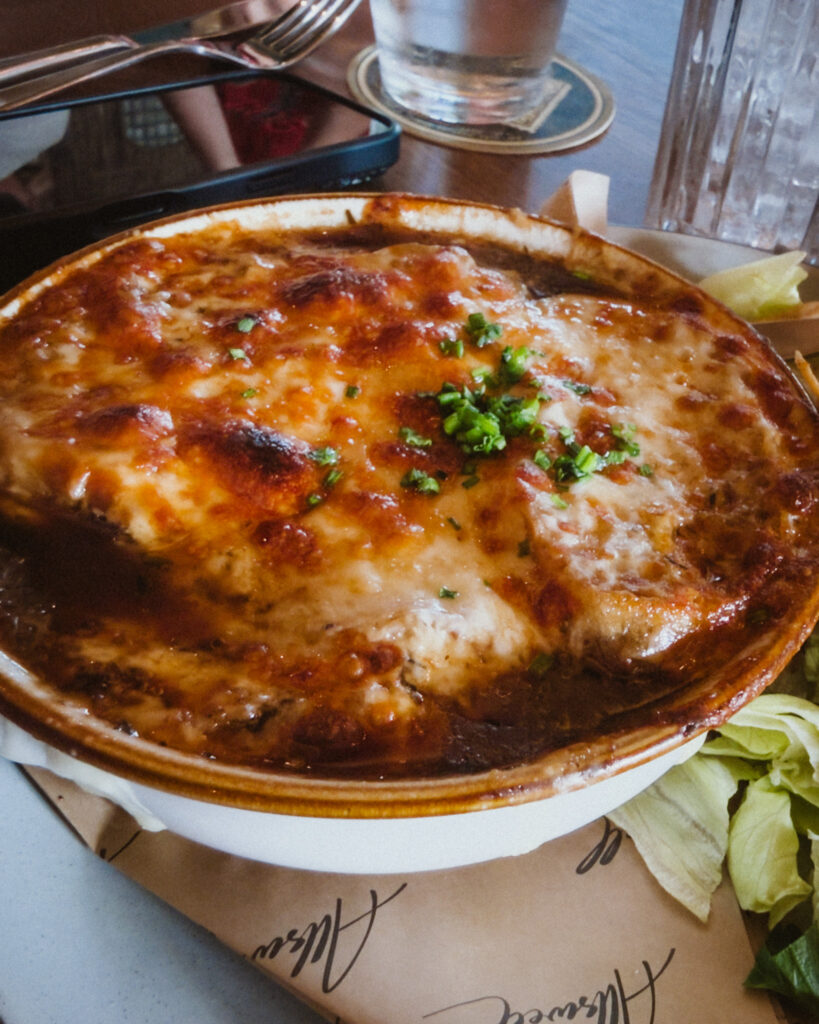 Allswell - Waterside Place Review 76 French onion soup at Allswell with a broiled cheese crust and chives, made with bone broth and a house crouton