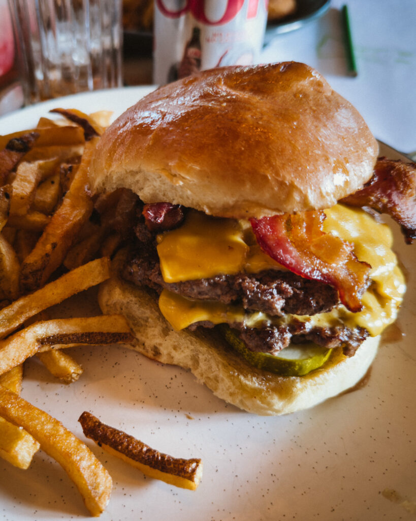 Allswell - Waterside Place Review 80 Allswell Burger with double smash patties, American cheese, applewood smoked bacon, and pickles on a brioche bun with fries