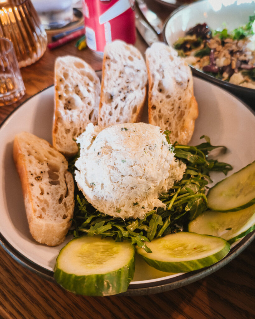 Allswell - Waterside Place Review 75 Roasted fish dip at Allswell served chilled with grilled crostini, cucumber slices, and arugula